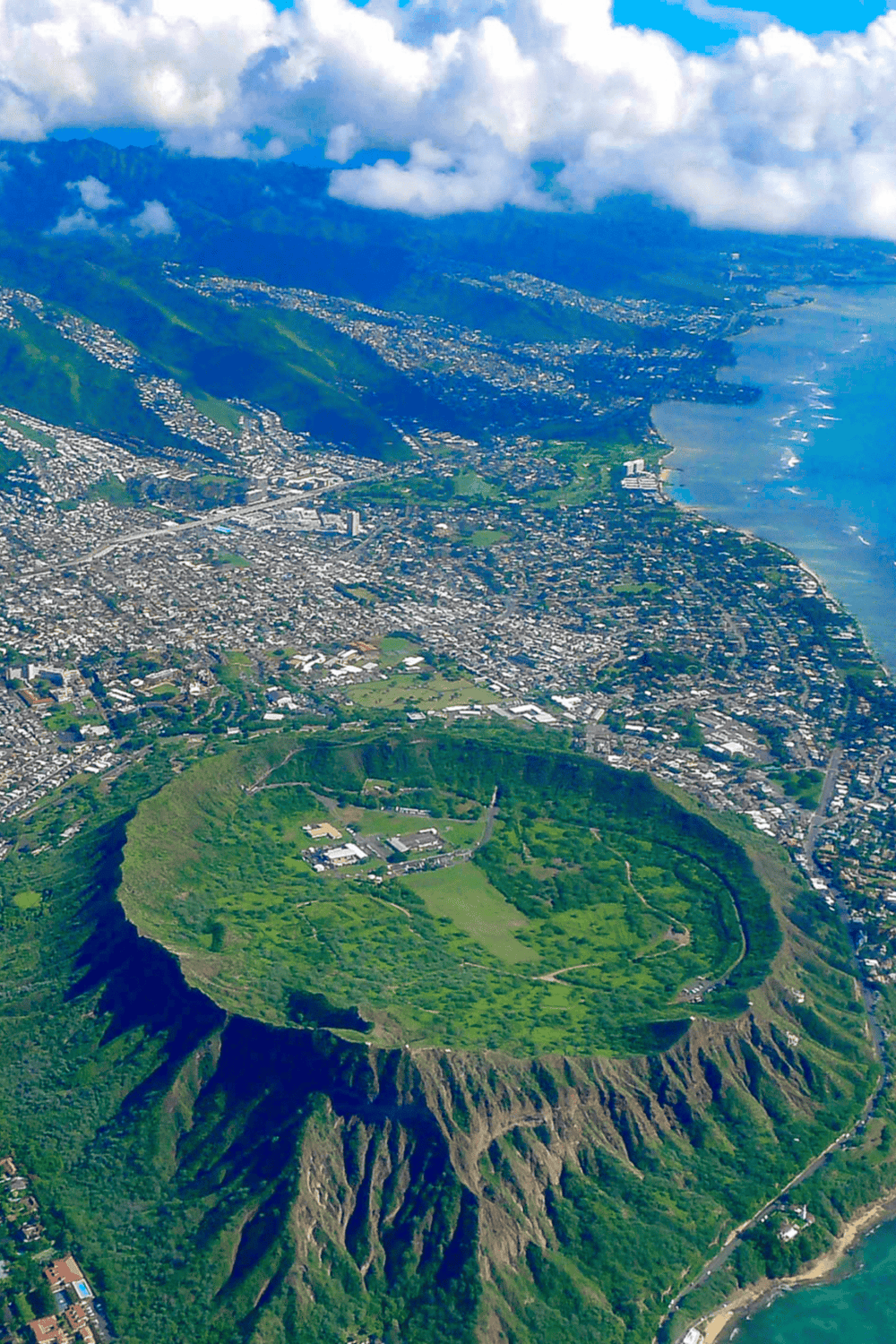 Colorful aerial view of Diamond Head volcano and Honolulu cityscape with lush greenery and ocean in Hawaii.
