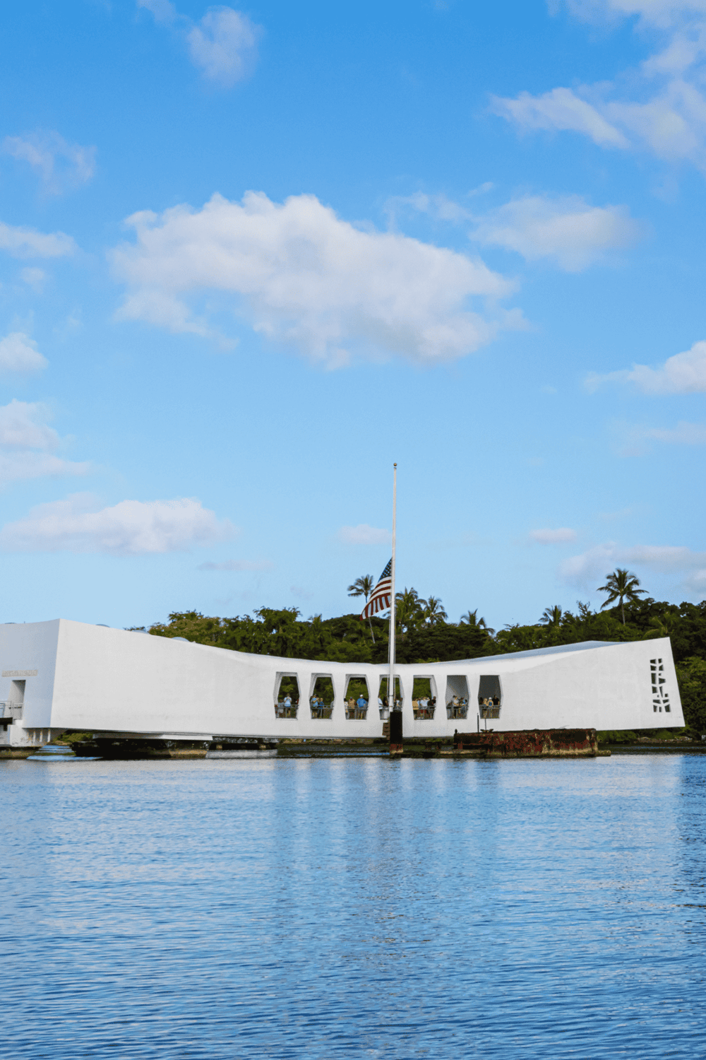 Modern building with unique architecture on water reflecting scenic views.