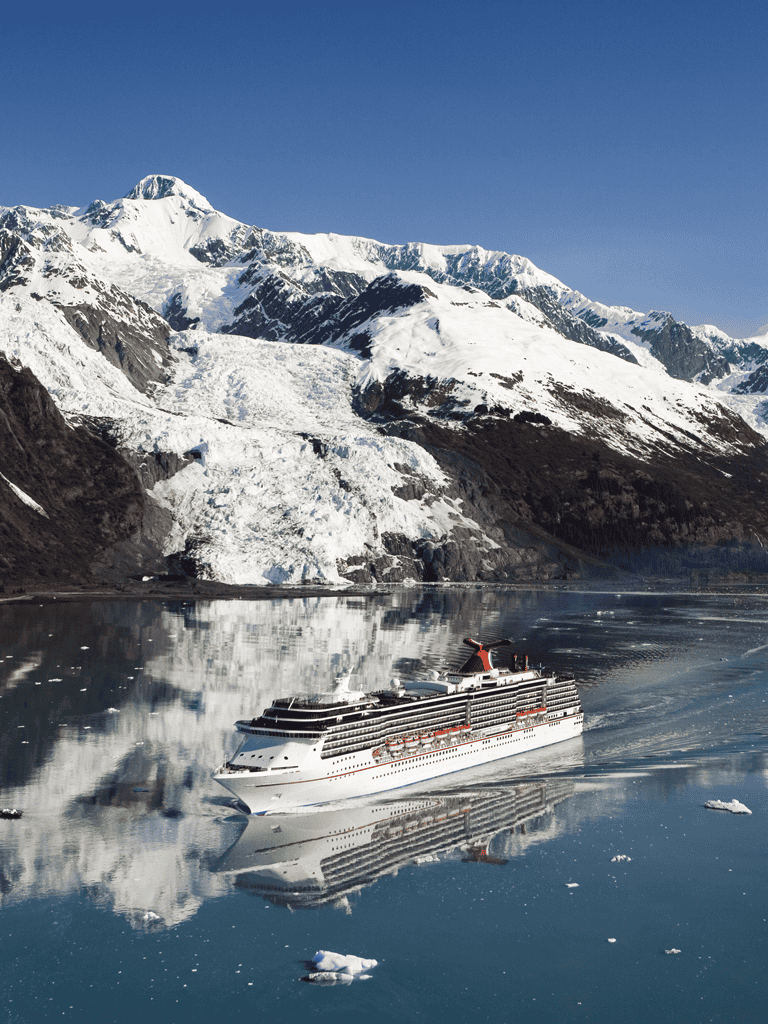 Spectacular glacier and snow-capped mountains with cruise ship on icy fjord in Alaska.