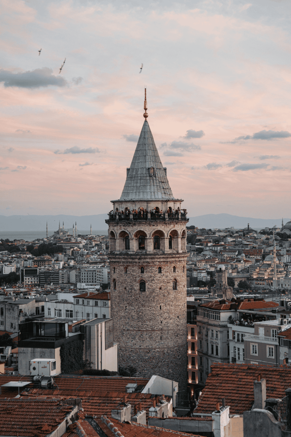 Ancient Galata Tower in Istanbul, Turkey, with panoramic city views at sunset, a top travel destination.