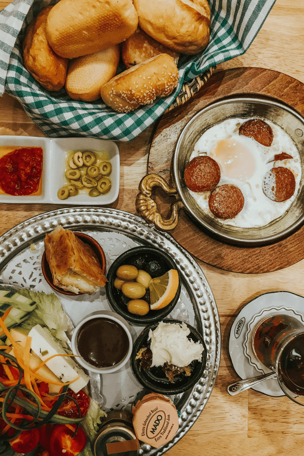 Fresh baked bread and traditional Turkish breakfast spread with olives, eggs, and pastries.