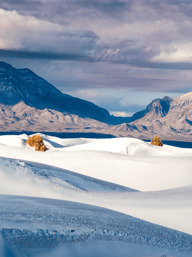 Expansive snow-covered landscape with mountains in the background, perfect for outdoor adventure and travel planning.
