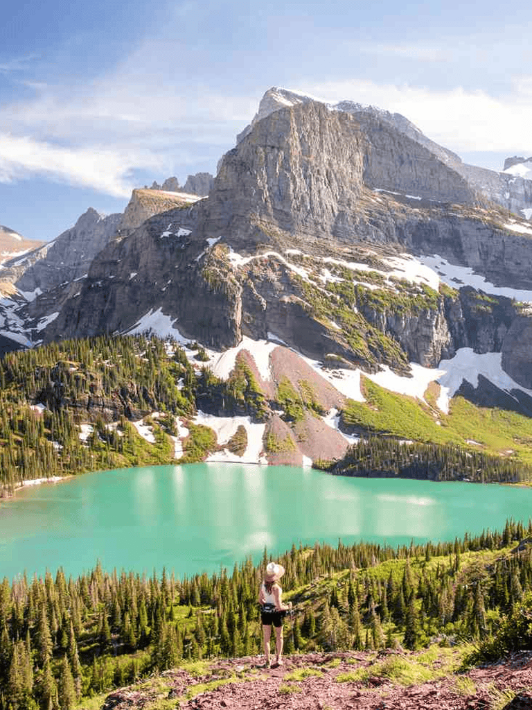 Stunning mountain landscape with turquoise lake and hiker in alpine scenery.