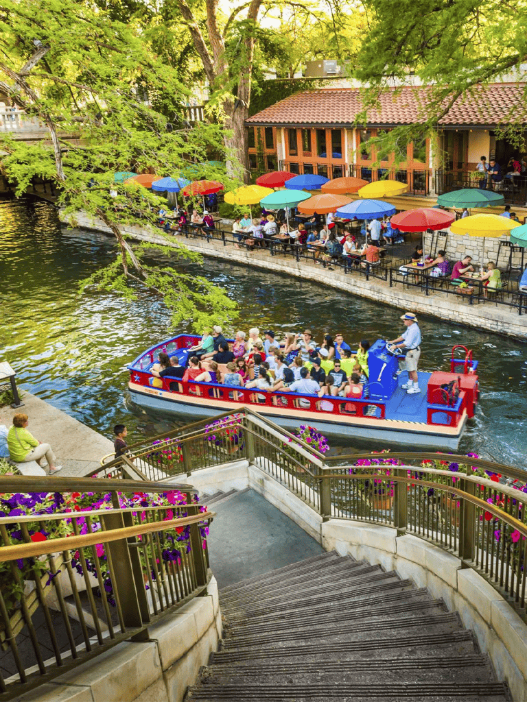 Bright riverboat tour in quest for directions canal with colorful umbrellas and scenic historic backdrop.