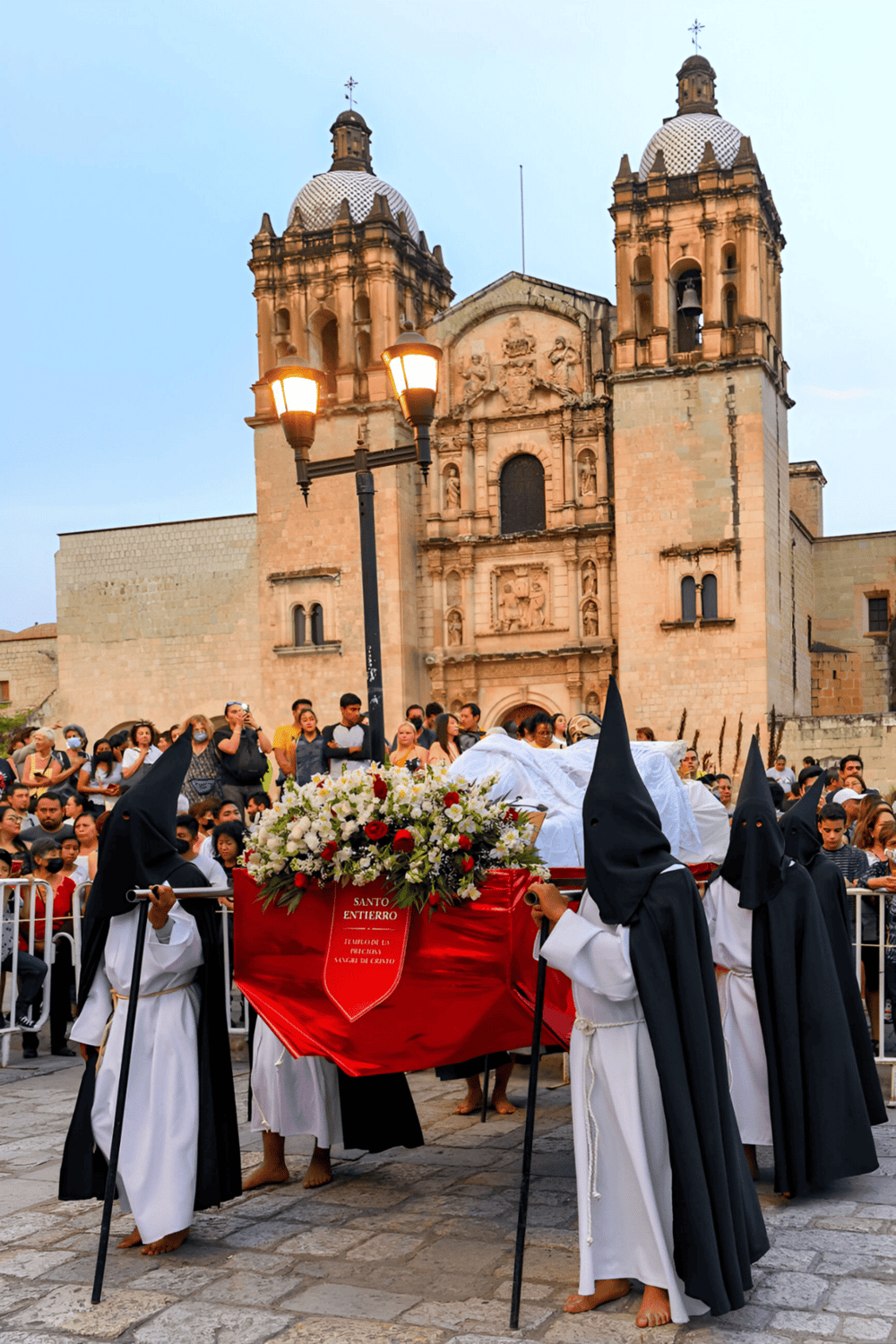 Colors of Holy Week procession in front of historic church in Mexico, traditional religious event.