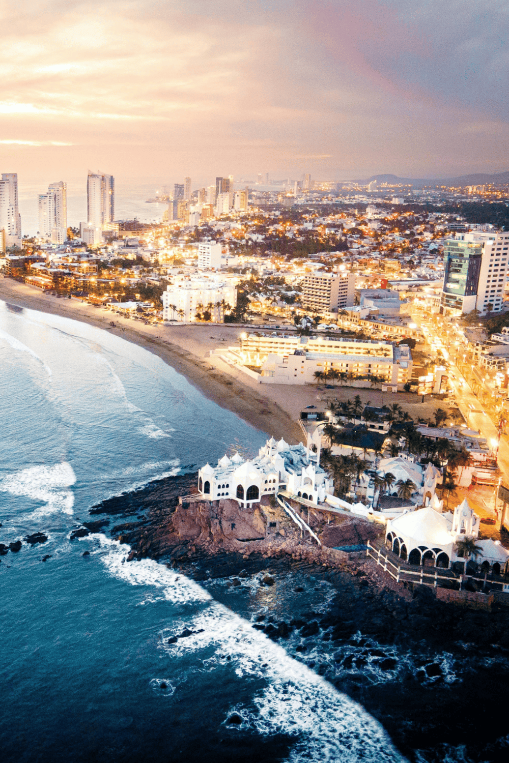 Luxury coastal cityscape with beachfront and high-rise buildings at sunset.