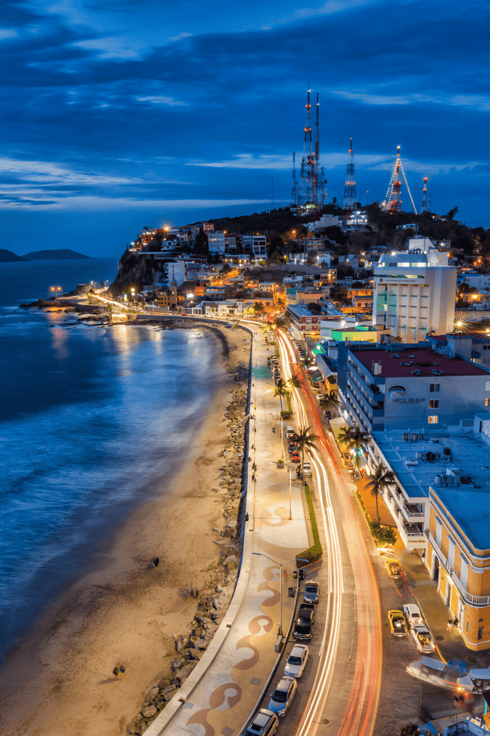 Vibrant nighttime coastal cityscape with illuminated streets and ocean views, highlighting QuestForDirections services.