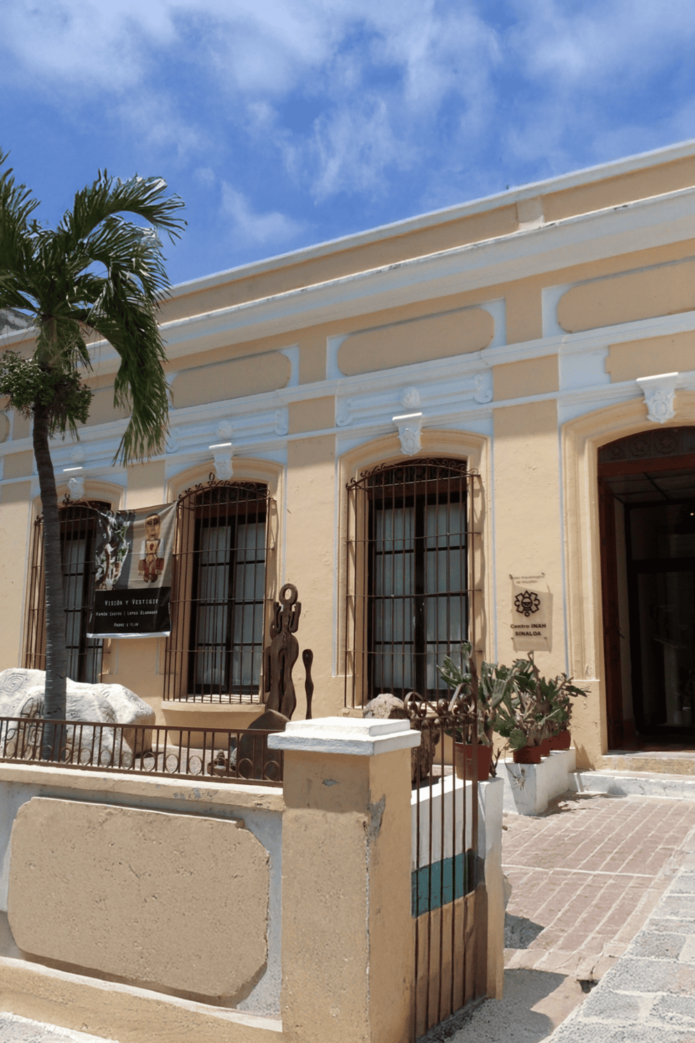 Historic building with vibrant yellow walls and decorative white accents, located in Sinaloa.