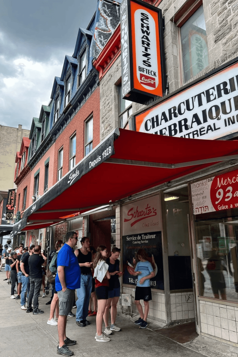 Waiting in line outside a popular Montreal restaurant, showcasing local cuisine and vibrant city life.