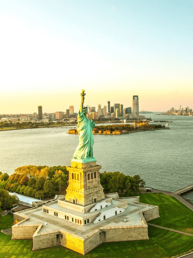 Aerial view of Statue of Liberty with New York City skyline skyline in background.