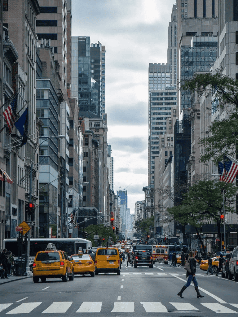 Busy New York City street with taxis and pedestrians, showcasing urban transportation and cityscape.