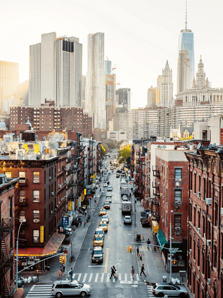 Cityscape featuring high-rise buildings and busy urban street in New York City, captured during daylight.