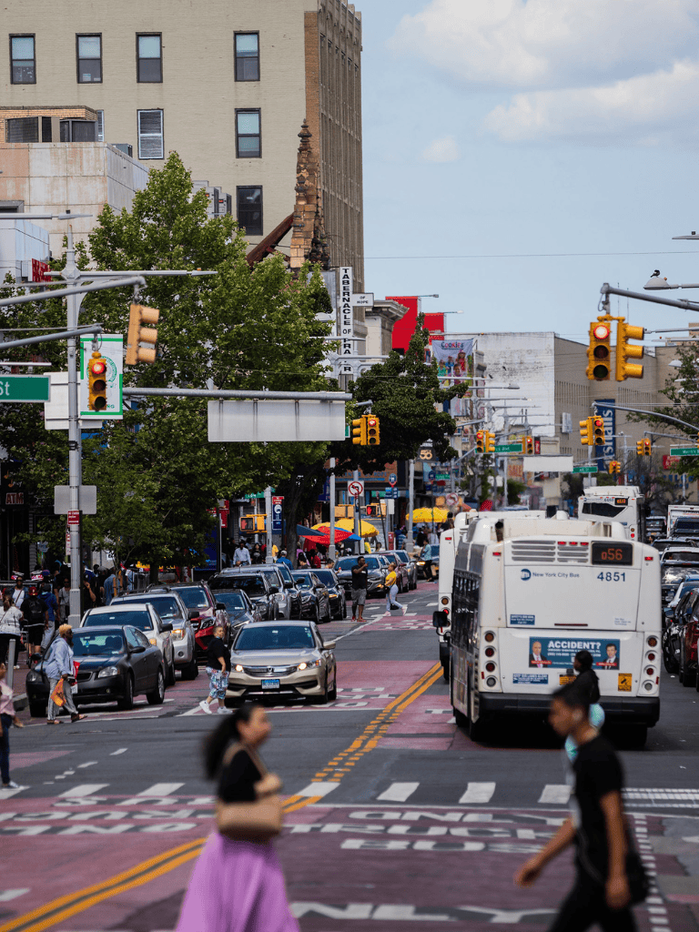 Busy urban street with traffic, pedestrians, and city buildings in New York City.