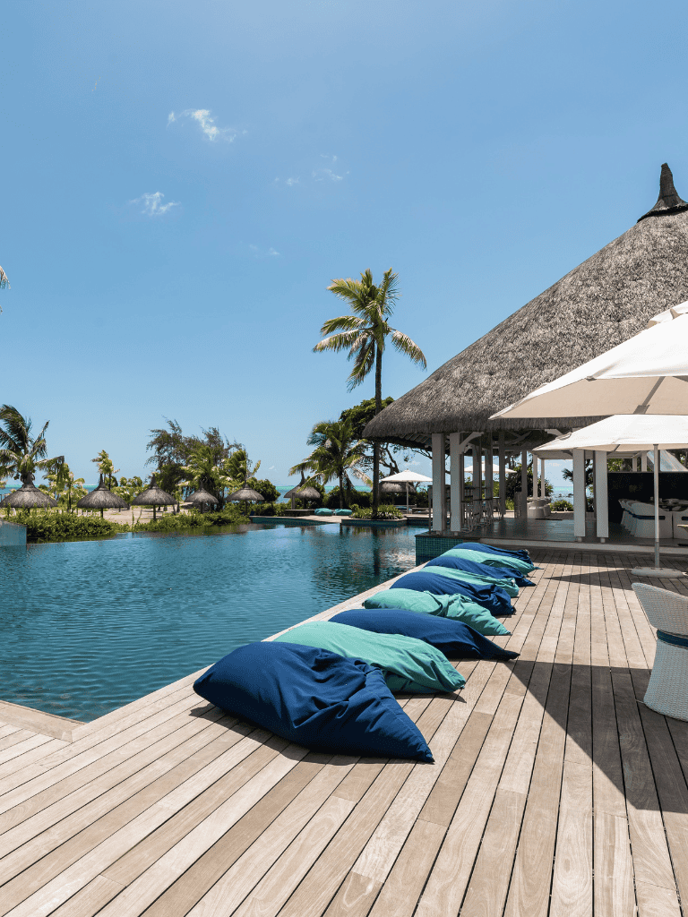 Relaxing poolside with tropical cabanas and palm trees, perfect for vacation at QuestForDirections resort.