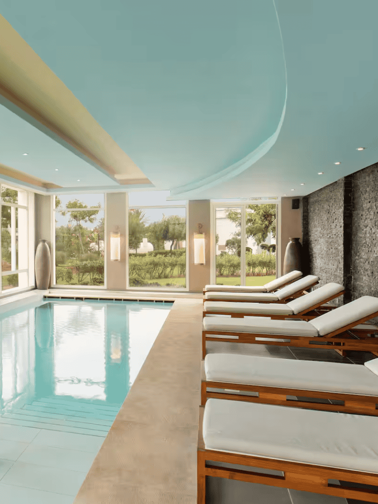 Luxurious indoor pool area at Quest for Directions with sun loungers and modern decor.