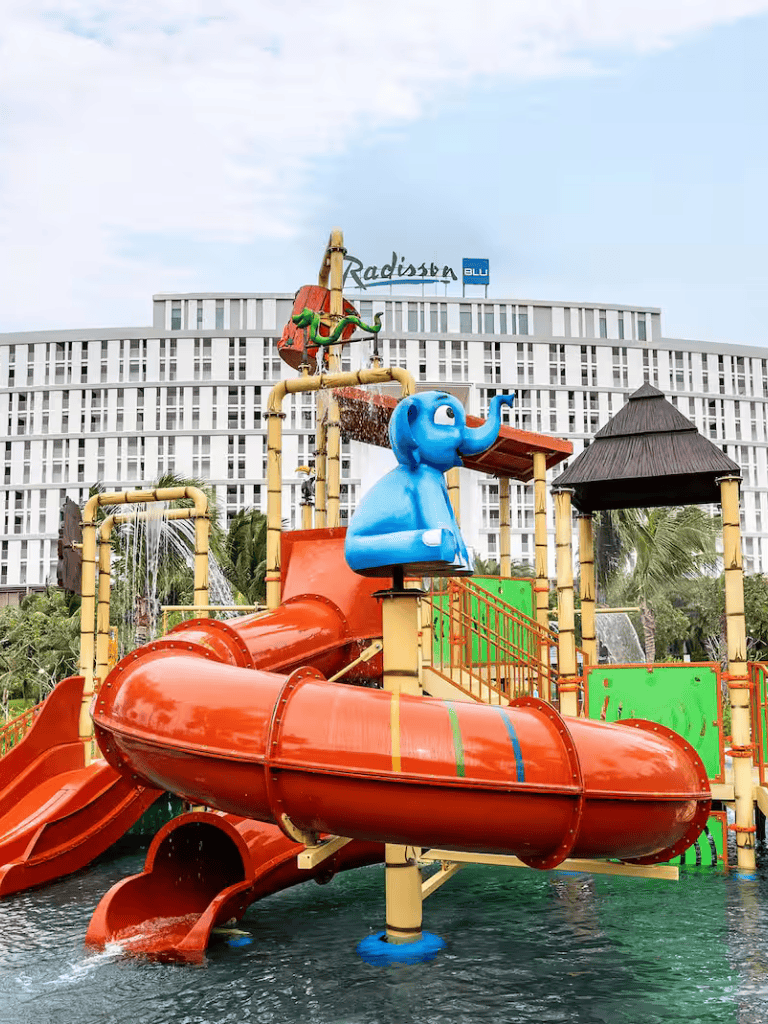 Colorful water park slide at QuestForDirections hotel, featuring vibrant elephant and jungle-themed decorations.