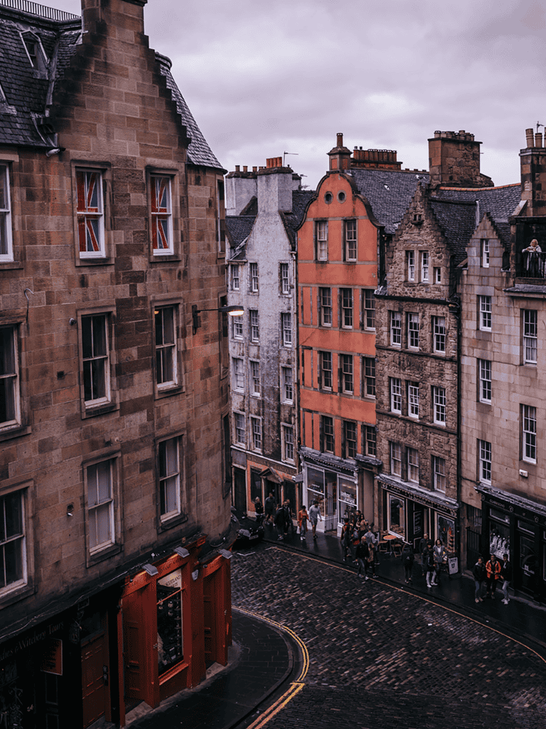 Cobblestone street in historic European city with colorful old buildings and pedestrians.