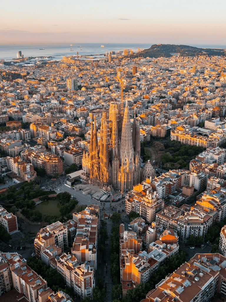 Majestic aerial view of La Sagrada Família in Barcelona at sunset showcasing iconic architecture.