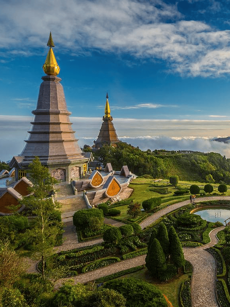 Ancient temple pagodas surrounded by lush gardens, scenic views, and cloudy skies, representing cultural heritage and spiritual tranquility.