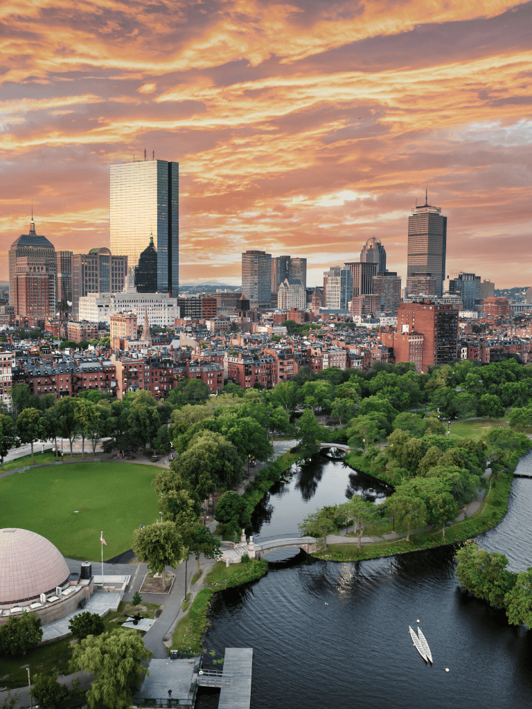 Vibrant Boston skyline featuring Downtown, green parks, and the Charles River at sunset.