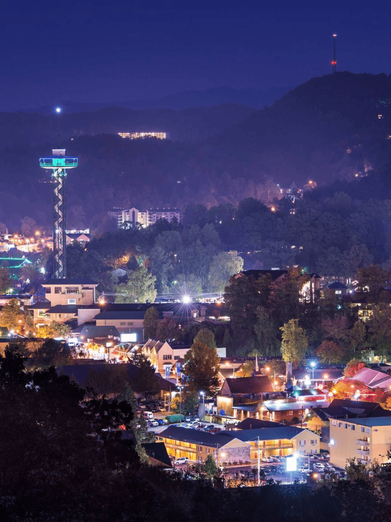 Vibrant night cityscape with illuminated buildings and mountain backdrop, showcasing QuestForDirections services.