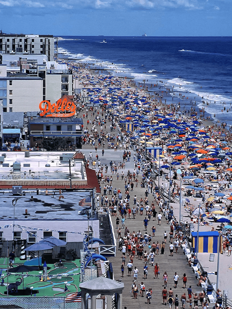 Crowded beach with colorful umbrellas and ocean view at Ocean City, Maryland.
