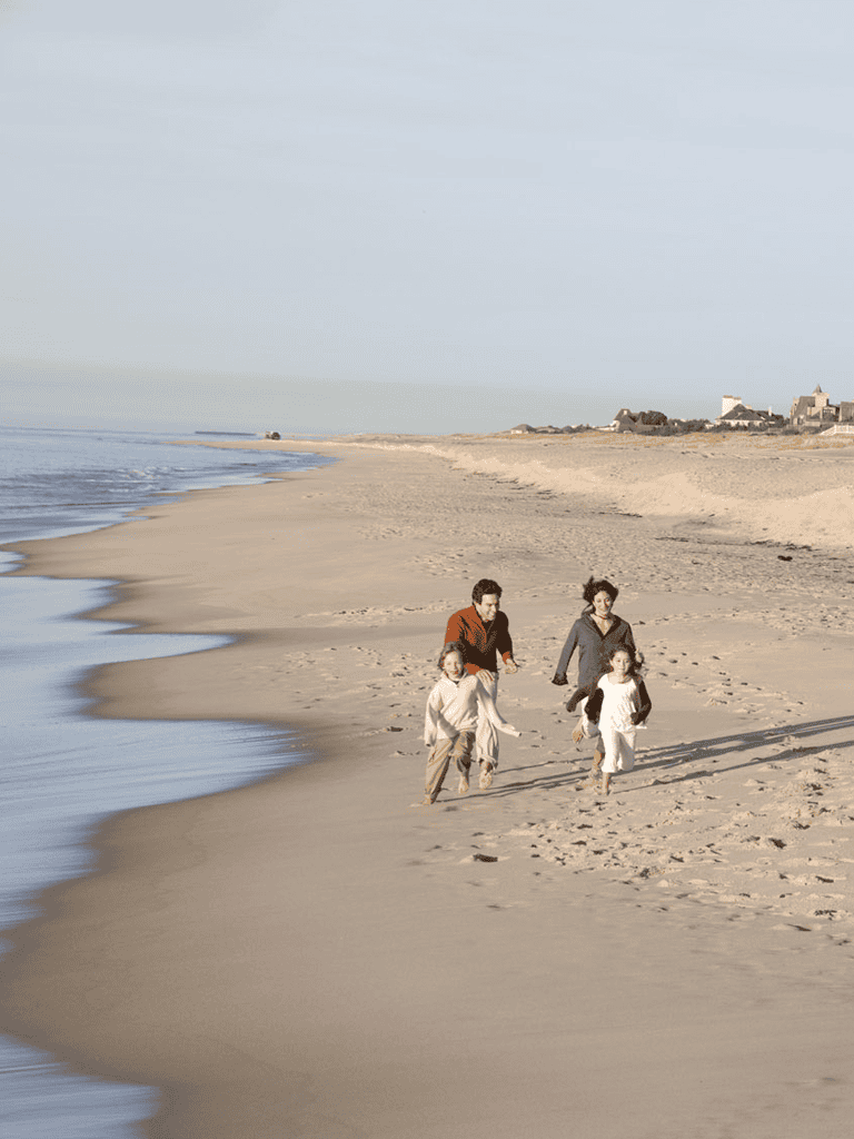 Family walking on beach at sunset, discovering scenic coastal views, fun outdoor adventure, QuestForDirections access and navigation.