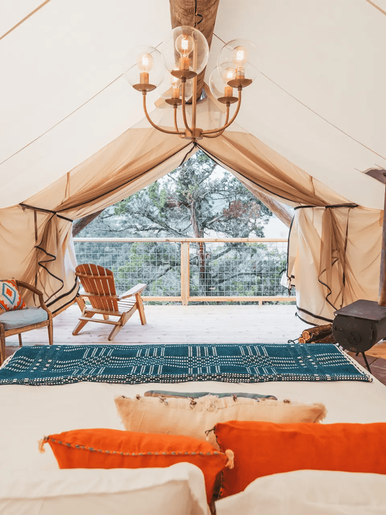 Cozy glamping tent with outdoor deck and mountain views, ideal for unique outdoor experiences.