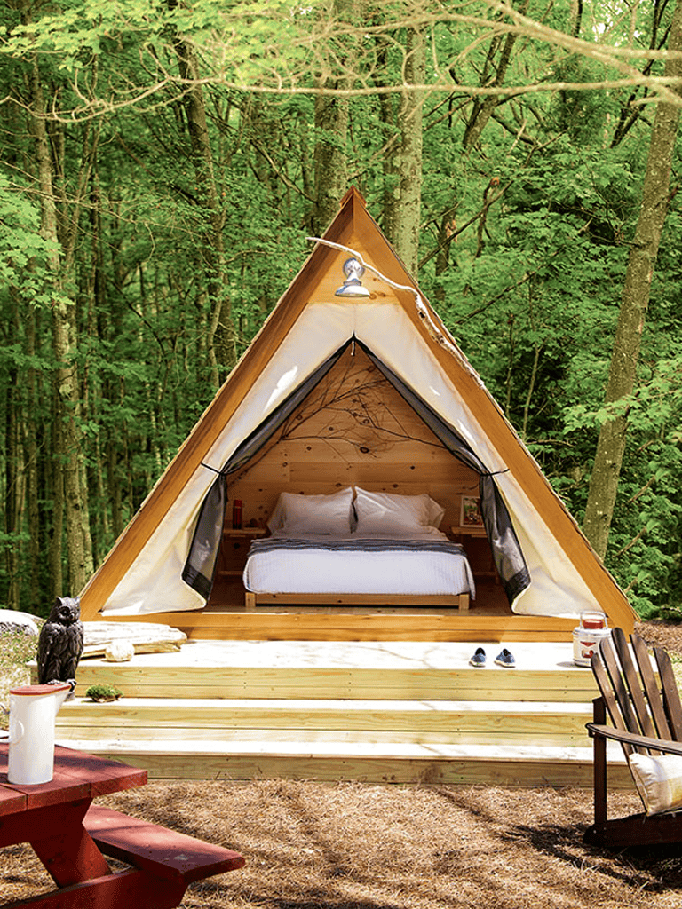 Cozy A-frame cabin in lush green woods, perfect for nature retreats and outdoor adventures.