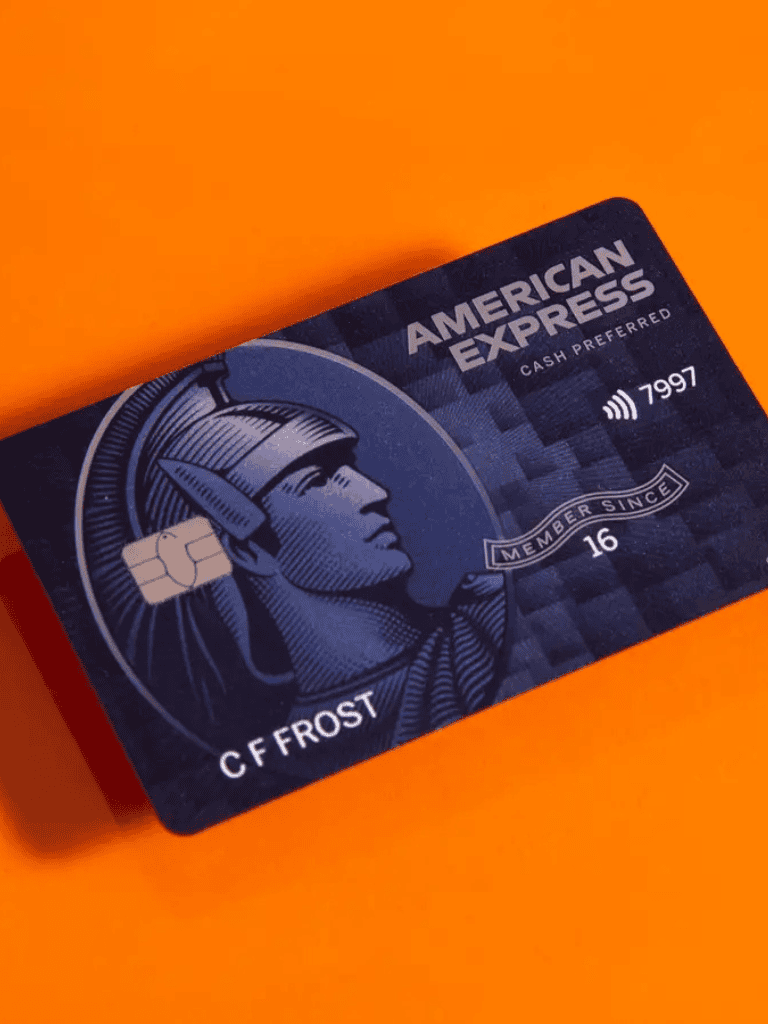 Front view of American Express credit card with chip on an orange background.