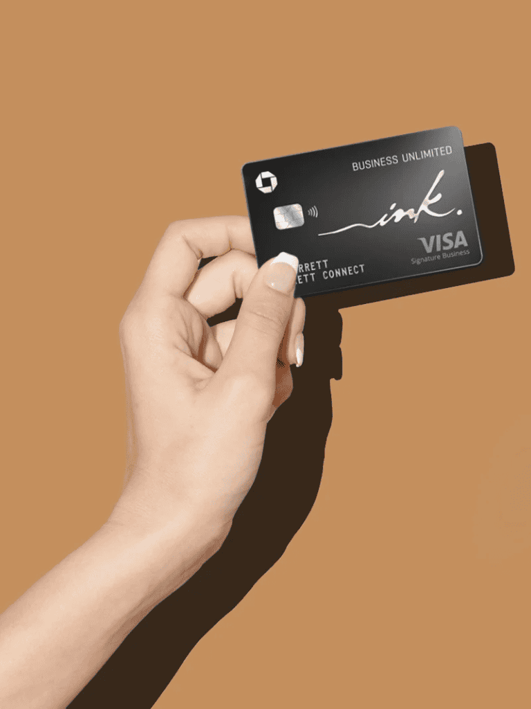 Visa credit card held by a hand against a brown background, emphasizing business and financial services.