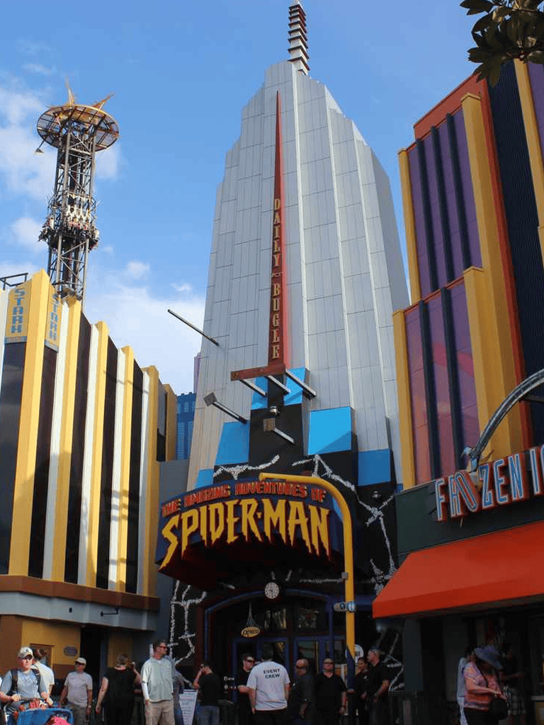 Spider-Man themed amusement park attraction with vibrant signage and visitors in front.