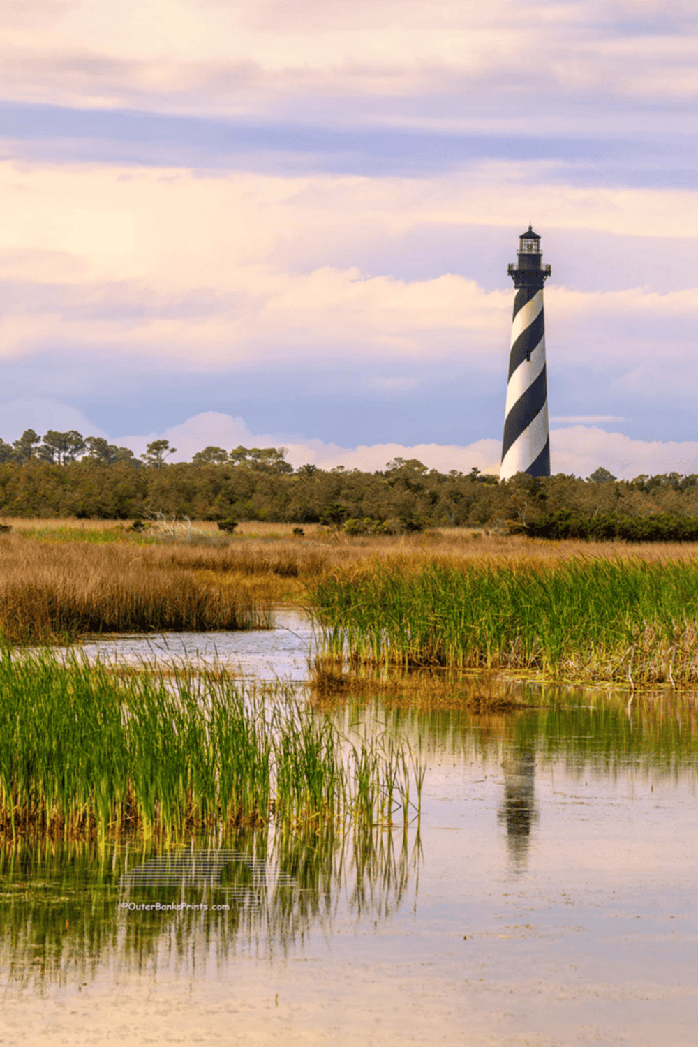 Lighthouse on marshlands at dusk, scenic coastal navigation, QuestForDirections for marine navigation.