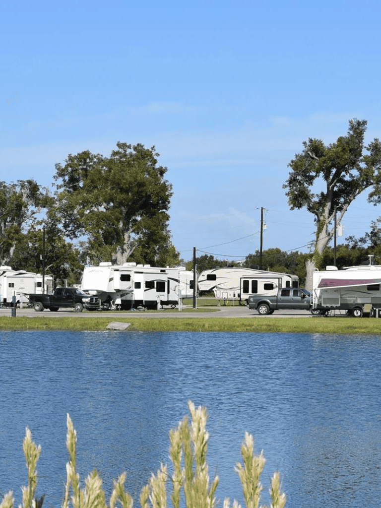 RVs parked near a lake with trees, showcasing outdoor adventure and camping at QuestForDirections.