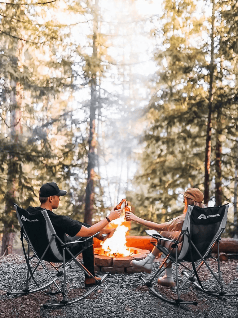 Cozy camping scene with friends sitting around a campfire in a forest setting for outdoor adventure.