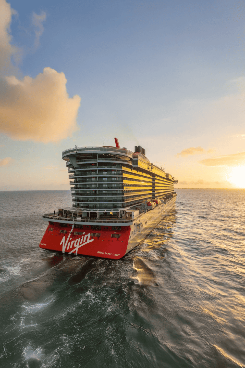 Luxury cruise ship on ocean at sunset with vibrant sunset sky.