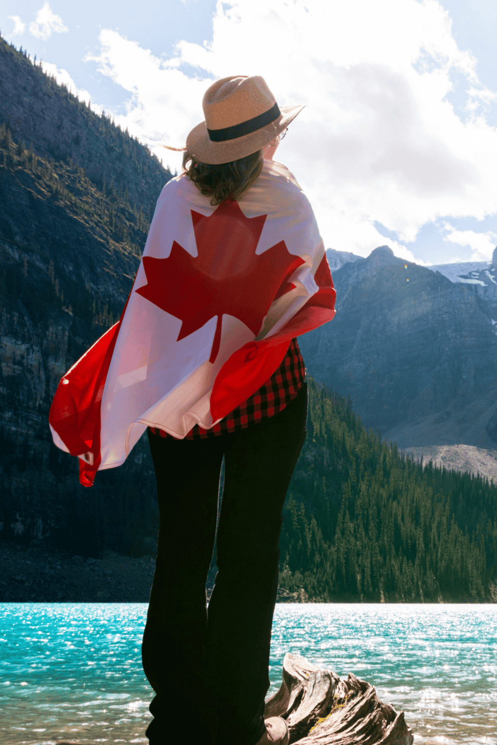 1. Woman with Canadian flag overlooking mountain lake and scenic wilderness.