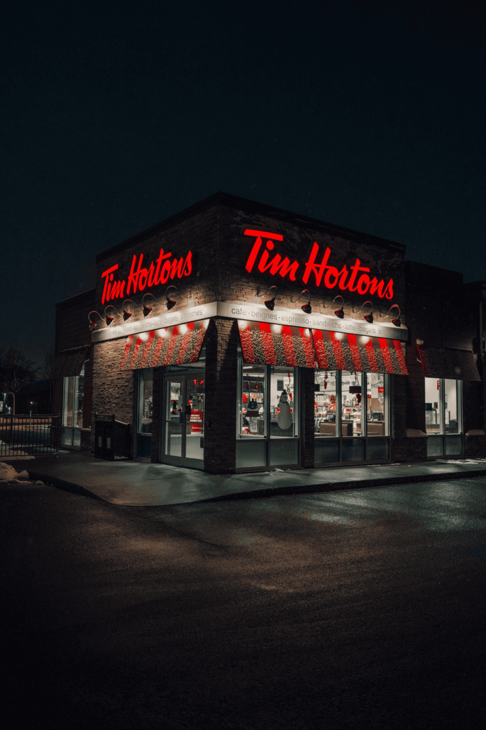 Tim Hortons coffee shop illuminated at night, featuring iconic red signage and cozy storefront.