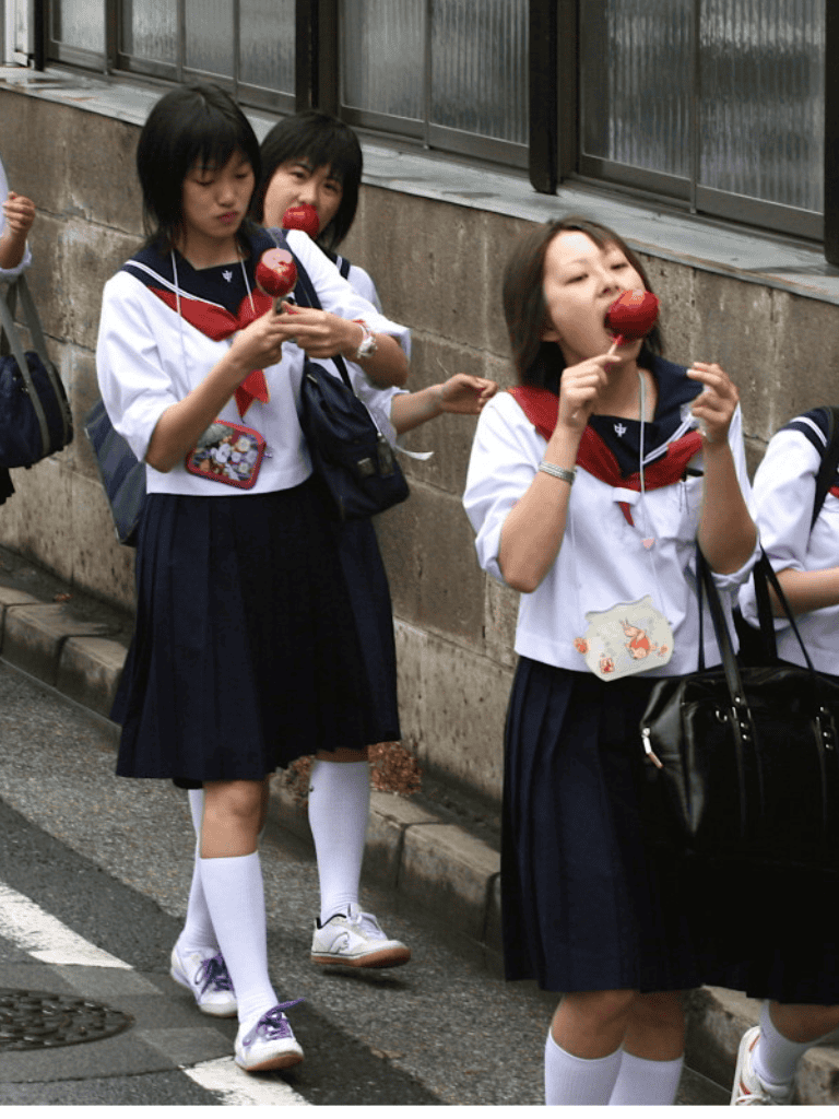 Cherry blossom-themed ice cream treats enjoyed by Japanese schoolgirls in uniform.