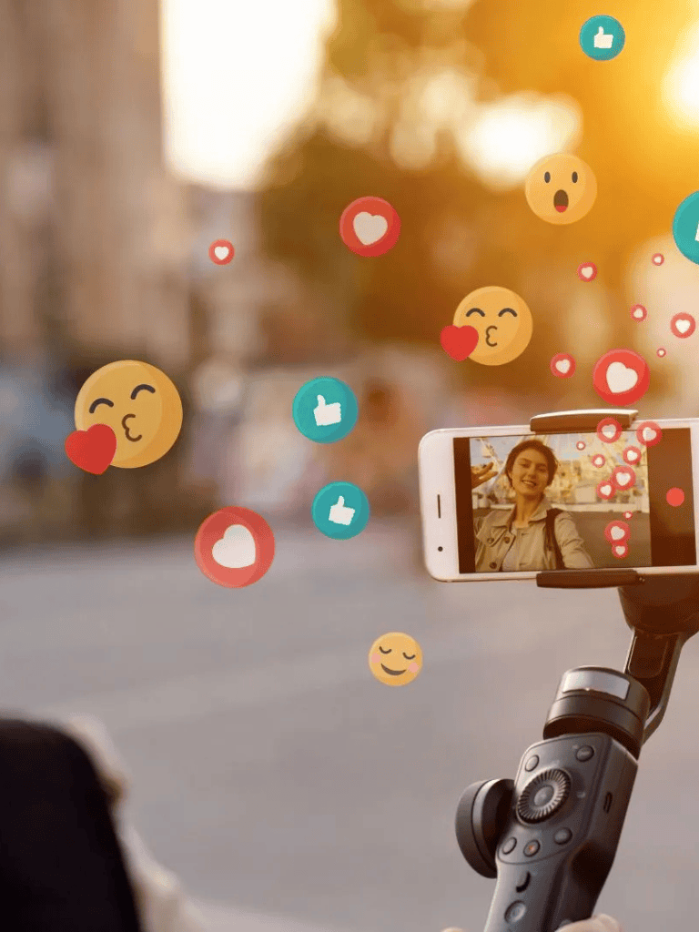 Smiling woman taking selfie with reaction emojis floating around, outdoor sunset background, QuestForDirections marketing image.