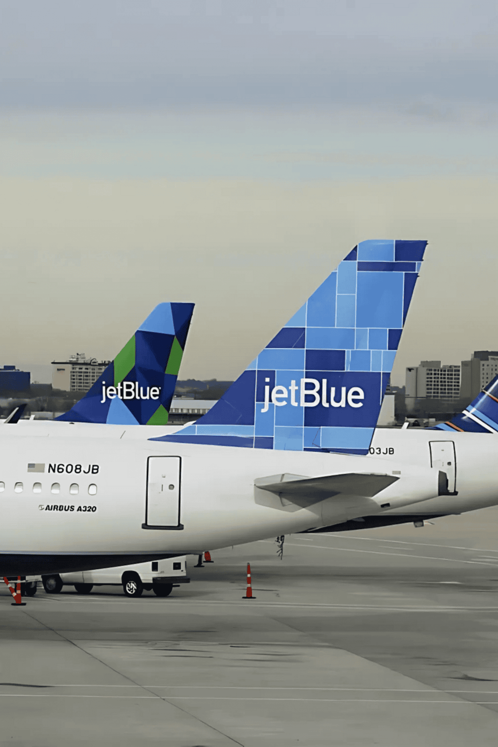 Aircraft tail fins with JetBlue branding at an airport.