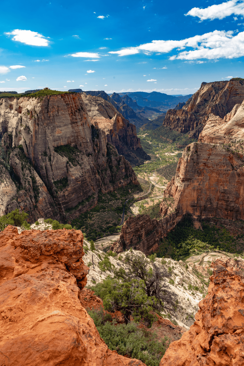 Breathtaking view of Zion Canyon with towering red rock cliffs in Zion National Park, Utah, under a vibrant blue sky.