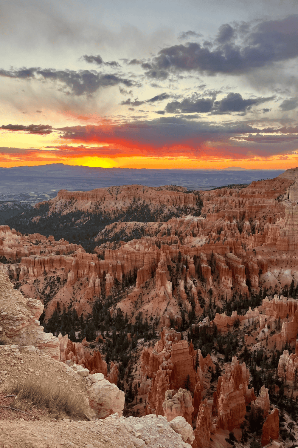 Vibrant sunset over Bryce Canyon with its iconic orange hoodoos and rugged landscape, capturing natural beauty and outdoor adventure.