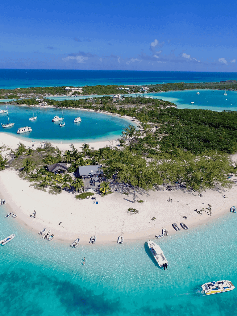 Boat marina at tropical island with crystal clear water and lush green scenery, scenic island destination for vacation.