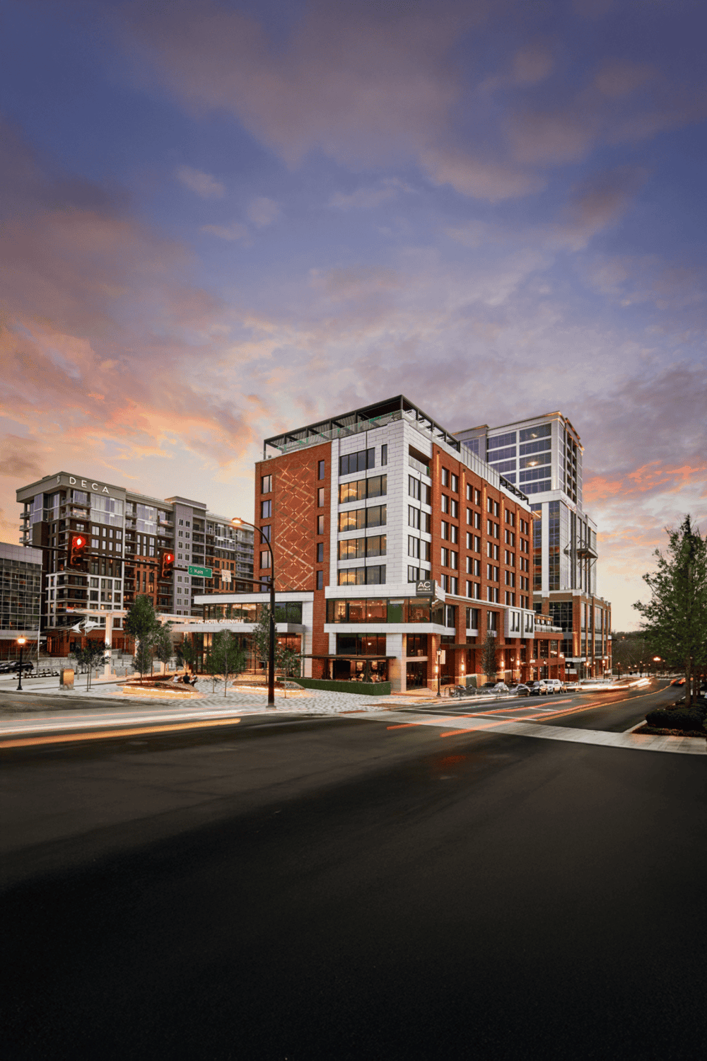 Modern urban hotel building with city street view at sunset, luxury accommodations, and downtown skyline.