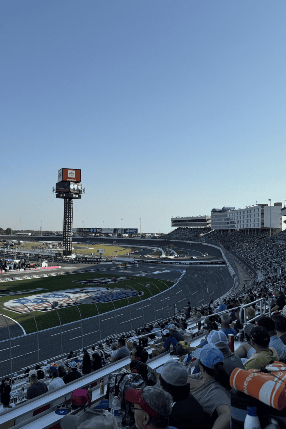 Race track at Las Vegas Motor Speedway during a NASCAR event, filled with cheering spectators.