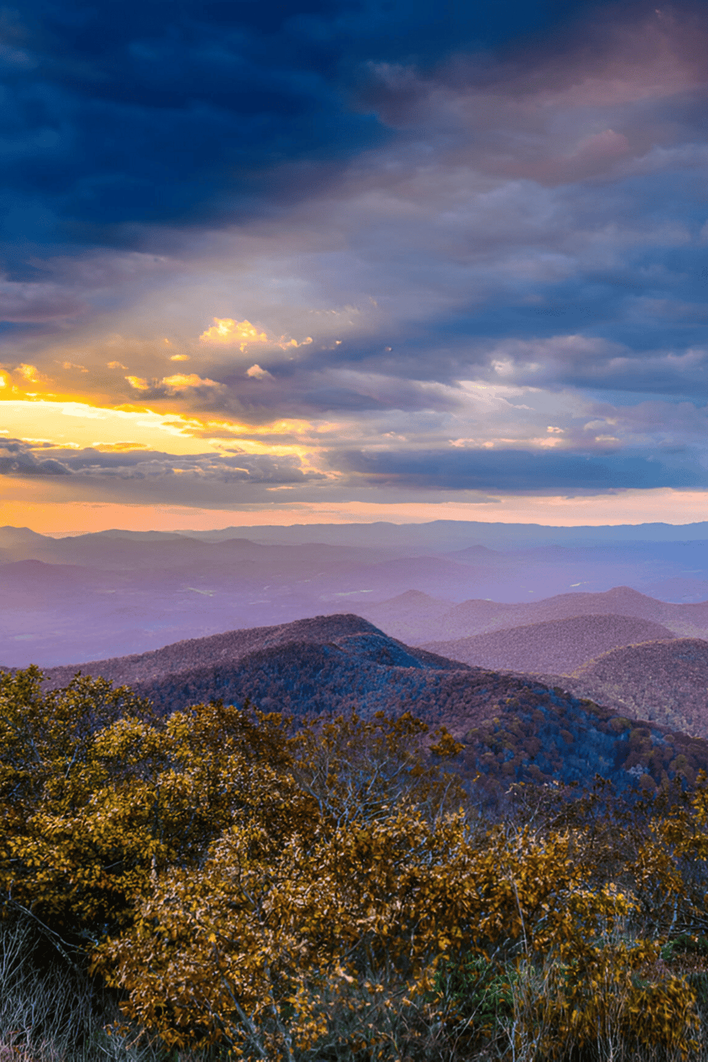Breathtaking mountain landscape during sunset with colorful sky and rolling hills.