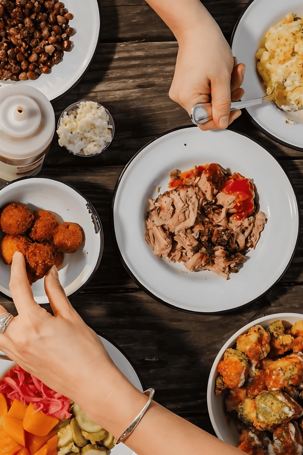 Savory meal with roasted chicken, fried appetizers, mashed potatoes, and vegetables on a wooden table.