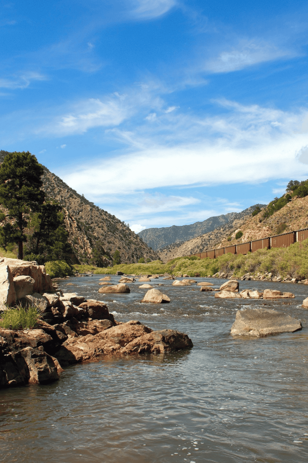 Flowing river through scenic canyon with mountains and blue sky, outdoor adventure, nature travel, QuestForDirections.