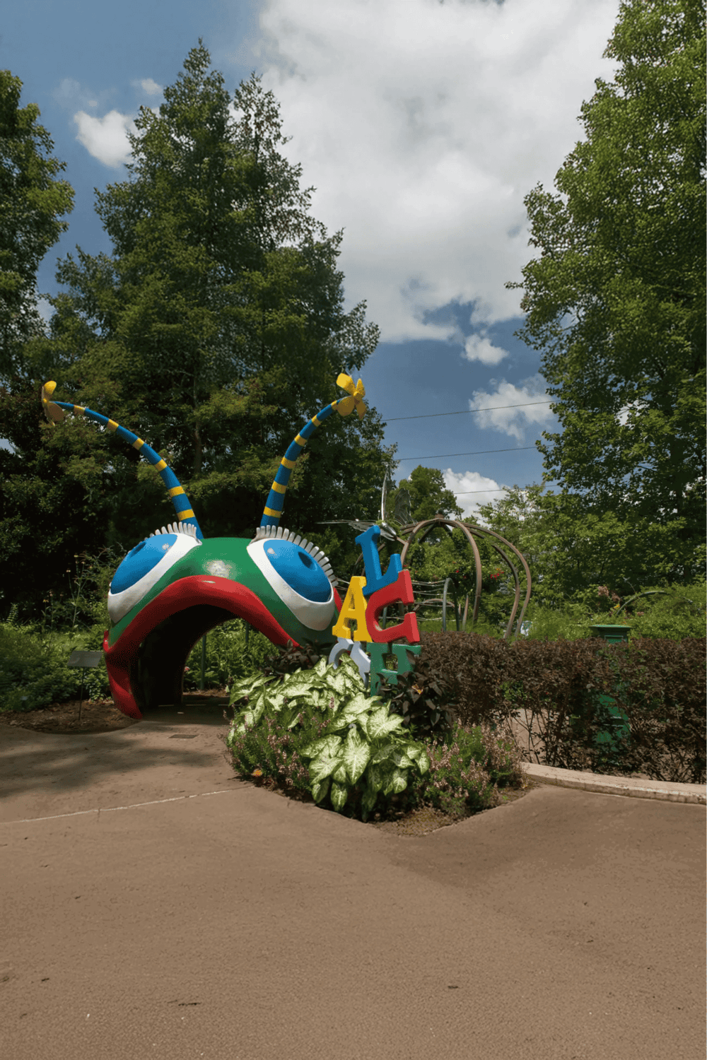Colorful insect sculpture at Quest for Directions botanical garden.